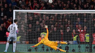 Penjaga gawang Liverpool Caoimhin Kelleher (kanan) menyaksikan tendangan penalti kiper Chelsea Kepa Arrizabalaga (kiri) melewati mistar gawang ketika adu penalti saat pertandingan sepak bola final Piala Liga Inggris / Carabao antara Chelsea dan Liverpool di Stadion Wembley, Inggris, Minggu (27/2/2022). [Glyn KIRK / AFP]