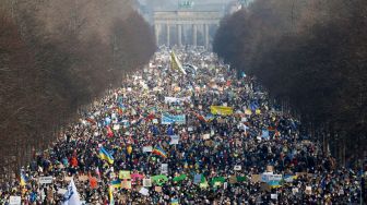 Para pengunjuk berdemonstrasi untuk perdamaian di Ukraina di dekat Gerbang Brandenburg, Berlin, Jerman, Minggu (27/2/2022). [Odd ANDERSEN / AFP]
