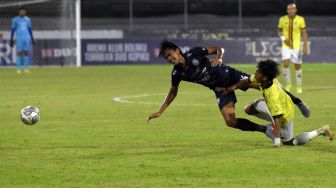 Pesepak bola Arema FC Jayus Hariono (kiri) berebut bola dengan pesepak bola Persik Kediri Yusuf (kanan) pada pertandingan Liga 1 di Stadion I Gusti Ngurah Rai, Denpasar, Bali, Minggu (27/2/2022). [ANTARA FOTO/Nyoman Hendra Wibowo/YU]