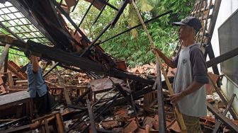 Warga membersihkan puing-puing bangunan sekolah Madrasah Aliyah Madarisul Ulum di Kampung Kenari, Kasemen, Serang, Banten, Jumat (4/3/2022). ANTARA FOTO/Asep Fathulrahman