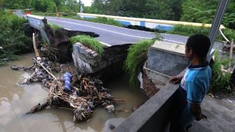 Warga melihat kondisi jembatan jalan yang ambrol di Kadirejo, Karanganom, Klaten, Jawa Tengah, Jumat (4/3/2022).  ANTARA FOTO/Aloysius Jarot Nugroho