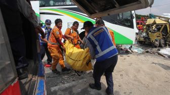 Petugas mengevakuasi jenazah korban kecelakaan bus pariwisata dengan truk di Tol Dupak - Tanjung Perak Surabaya, Jawa Timur, Sabtu (5/3/2022). ANTARA FOTO/Didik Suhartono