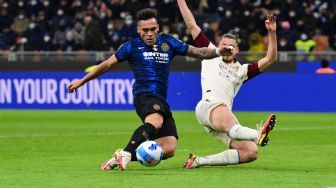 Penyerang Inter Milan Lautaro Martinez (kiri) menembak dan mencetak gol untuk timnya selama pertandingan sepak bola Serie A Italia antara Inter Milan melawan Salernitana di Stadion di Giuseppe Meazza, Sabtu (4/3/2022) dini hari WIB. MIGUEL MEDINA / AFP