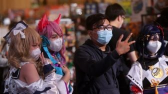 Pengunjung berfoto bersama cosplayer tokoh fiksi anime Jepang pada gelaran "The Jakarta 17th Toys & Comics Fair 2022" di Balai Sudirman, Jakarta, Sabtu (5/3/2022). [Suara.com/Angga Budhiyanto]