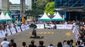 Pengunjung melihat atraksi motor saat Pameran UMKM Goes To Mandalika di Gedung Smesco, Jakarta Selatan, Minggu (6/3/2022). [Suara.com/Septian]