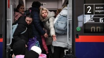 Pengungsi menaiki kereta yang membawa pengungsi ke Polandia, di stasiun kereta Lviv, Ukraina barat, Sabtu (5/3/2022). [Daniel LEAL / AFP]