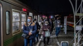 Penumpang turun di stasiun usai menaiki kereta yang populer untuk tur wisata malam hari yang melintasi jalur kereta Gakunan melalui kawasan industri di Fuji, prefektur Shizuoka, Jepang, Sabtu (26/2/2022). [Philip FONG / AFP]