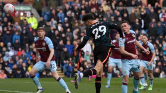 Gelandang Chelsea Kai Havertz (tengah) menyundul bola dan mencetak gol kedua untuk timnya saat pertandingan sepak bola Liga Premier Inggris antara Burnley dan Chelsea di Stadion Turf Moor, Inggris, Sabtu (5/3/2022). [Oli SCARFF / AFP]