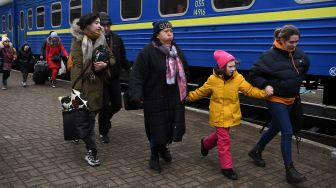 Pengungsi bergegas naik kereta yang akan membawa pengungsi ke Polandia di stasiun kereta Lviv, Ukraina barat, Sabtu (5/3/2022). [Daniel LEAL / AFP]