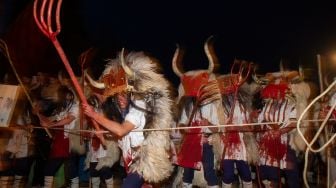 Orang-orang mengenakan kostum Momotxorro saat karnaval tradisional Alsasua di Alsasua, provinsi Navarra, Spanyol, Selasa, (1/3/2022). [ANDER GILLENEA / AFP]