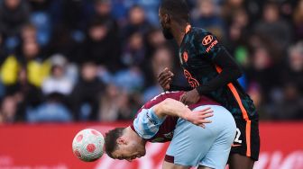 Striker Burnley Ashley Barnes (kiri) berebut bola dengan bek Chelsea Antonio Rudiger saat pertandingan sepak bola Liga Premier Inggris antara Burnley dan Chelsea di Stadion Turf Moor, Inggris, Sabtu (5/3/2022). [Oli SCARFF / AFP] 
