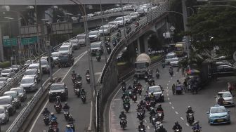 Sejumlah kendaraan melintas di Jalan Gatot Subroto, Jakarta, Senin (7/3/2022). [Suara.com/Angga Budhiyanto]