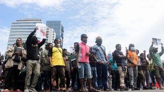 Puluhan aktivis papua menggelar aksi demo di depan Monas, Jakarta Pusat, Senin (7/3/2022). [Suara.com/Septian]