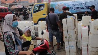 Sejumlah pedagang mengantre untuk mendapatkan minyak goreng curah di Pasar Kebayoran Lama, Jakarta, Rabu (9/3/2022). [Suara.com/Angga Budhiyanto] 