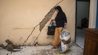 Warga membawa barang-barangnya dari rumahnya yang rusak akibat pergerakan tanah di Desa Pasir Suren, Kecamatan Palabuhanratu, Kabupaten Sukabumi, Jawa Barat, Rabu (9/3/2022). ANTARA FOTO/Iman Firmansyah
