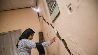 Warga melihat kondisi bagian rumahnya yang rusak akibat pergerakan tanah di Desa Pasir Suren, Kecamatan Palabuhanratu, Kabupaten Sukabumi, Jawa Barat, Rabu (9/3/2022).  ANTARA FOTO/Iman Firmansyah