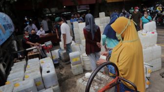 Sejumlah pedagang mengantre untuk mendapatkan minyak goreng curah di Pasar Kebayoran Lama, Jakarta, Rabu (9/3/2022). [Suara.com/Angga Budhiyanto] 