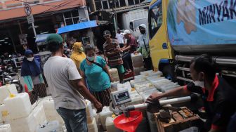 Sejumlah pedagang mengantre untuk mendapatkan minyak goreng curah di Pasar Kebayoran Lama, Jakarta, Rabu (9/3/2022). [Suara.com/Angga Budhiyanto] 