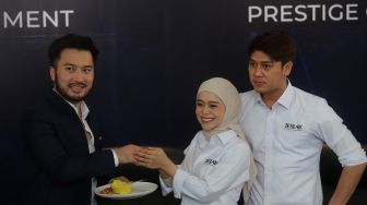 Presiden Direktur Prestige Motorcars Rudy Salim (kiri) menerima potongan tumpeng dari Pendiri Leslar Entertainment Lesti Kejora (tengah) usai menandatangani akuisisi Leslar Entertainment oleh Prestige Corp di Prestige Image Corp, Pluit, Jakarta, Jumat (11/3/2022). [Suara.com/Angga Budhiyanto]