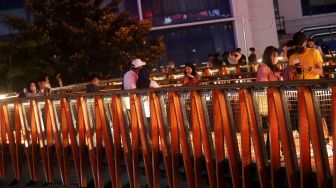 Sejumlah warga berfoto di Jembatan Penyeberangan Orang (JPO) Pinisi Karet-Sudirman, Jakarta, Sabtu (12/3/2022). [Suara.com/Angga Budhiyanto]