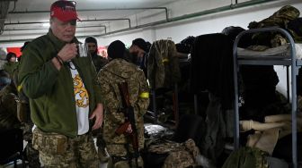 Kenneth Gregg (58) dari Finlandia, menyeruput tehnya usai menginstruksikan strategi tentang perang gerilya kota dan taktik kepada Pasukan Pertahanan Teritorial Ukraina di garasi bawah tanah yang telah diubah menjadi basis pelatihan dan logistik di Kyiv, Ukraina, Jumat (11/3/2022). [Sergei SUPINSKY / AFP] 