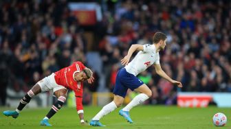 Bek Tottenham Hotspur Ben Davies (kanan) melarikan diri dari striker Manchester United Marcus Rashford (kiri) saat pertandingan sepak bola Liga Premier Inggris antara Manchester United dan Tottenham Hotspur di Stadion Old Trafford, Manchester, Inggris, Sabtu (12/3/2022). [Lindsey Parnaby / AFP]