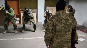 Prajurit Pasukan Pertahanan Teritorial Ukraina mengikuti pelatihan militer di garasi bawah tanah yang telah diubah menjadi pangkalan pelatihan dan logistik di Kyiv, Ukraina, Jumat (11/3/2022). [Sergei SUPINSKY / AFP]