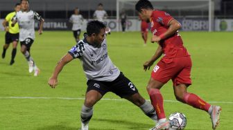 Pesepak bola Persikabo 1973 Andy Setyo (kiri) berebut bola dengan pesepak bola Persija Jakarta Taufik Hidayat (kanan) pada pertandingan Liga 1 di Stadion Kompyang Sujana, Denpasar, Bali, Minggu (13/3/2022). [ANTARA FOTO/Nyoman Hendra Wibowo/hp]