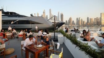 Orang-orang mengunjungi Dubai International Boat Show di Uni Emirat Arab, Minggu (13/2/2022). [Karim SAHIB / AFP]