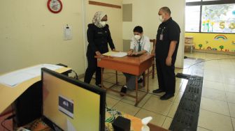 Pelajar didampingi pengajar mengikuti ujian sekolah berbasis nasional di SMA SLBA Pembinaan Tingkat Nasional Jakarta, Senin (14/3/2022). [ANTARA FOTO/Reno Esnir/aww]