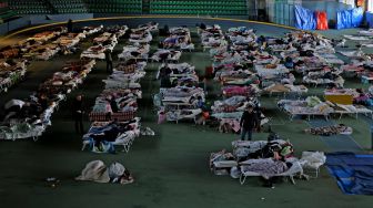 Para pengungsi dari Ukraina berlindung di aula utama kompleks atletik di ibukota Kishinev, Moldova, Kamis (10/3/2022). [MENAHEM KAHANA / AFP]
