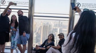 SPengunjung berfoto dengan latar belakang Kota Dubai di atas gedung Burj Khalifa di Uni Emirat Arab, Senin (14/3/2022). [ANTARA FOTO/M Agung Rajasa/wsj]