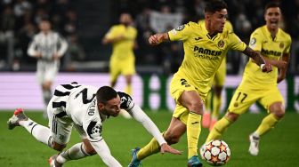 Bek Villarreal Mario Gaspar (kanan) mengungguli bek Juventus Italia Mattia De Sciglio saat pertandingan leg kedua babak 16 besar UEFA Liga Champions antara Juventus dan Villarreal di Stadion Juventus, Turin, Italia, Rabu (17/3/2022). [Marco BERTORELLO / AFP]