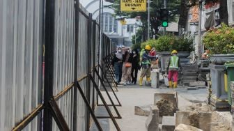 Pekerja membongkar jalur pedestrian di Kawasan Kota Tua, Jakarta, Kamis (17/3/2022). [Suara.com/Septian]