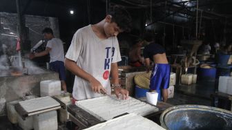 Pekerja memproduksi tahu dan tempe berbahan dasar kedelai di kawasan Duren Tiga Raya, Jakarta selatan, Jumat (18/3/2022). [Suara.com/Alfian Winanto]