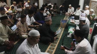 Umat muslim membaca surah Yasin di malam nisfu Syaban 15 Sya'ban 1443 Hijriah di Masjid Nurul Huda, Jakarta, Kamis (17/3/2022).  [Suara.com/Oke Atmaja]