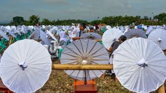 Sejumlah siswa melukis payung geulis pada Festival, Lomba dan Rekor Melukis 2022 Payung Geulis Se-Jawa Barat di SMA Negeri 10 Kota Tasikmalaya, Jawa Barat, Sabtu (19/3/2022). [ANTARA FOTO/Adeng Bustomi/rwa]
