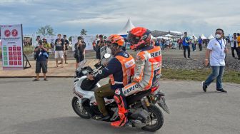 Pembalap Repsol Honda Team Marc Marquez membonceng marshal usai terjatuh saat kualifikasi MotoGP di Pertamina Mandalika International Street Circuit, Praya, Lombok Tengah, NTB, Sabtu (19/3/2022). [ANTARA FOTO/Ahmad Subaidi/rwa]
