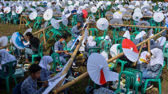 Sejumlah siswa melukis payung geulis pada Festival, Lomba dan Rekor Melukis 2022 Payung Geulis Se-Jawa Barat di SMA Negeri 10 Kota Tasikmalaya, Jawa Barat, Sabtu (19/3/2022). [ANTARA FOTO/Adeng Bustomi/rwa]