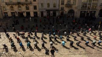 Ratusan kereta dan keranjang bayi kosong di pajang di luar gedung dewan kota di Lviv, Ukraina, Jumat (18/3/2022). [Yuriy Dyachyshyn / AFP]
