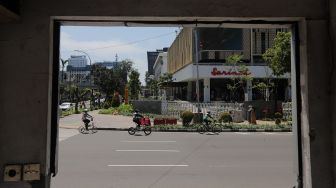 Pesepeda melintas di depan Gedung Sarinah pascarenovasi di Jakarta, Minggu (20/3/2022). [Suara.com/Angga Budhiyanto]