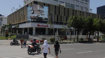 Warga berjalan di depan Gedung Sarinah pascarenovasi di Jakarta, Minggu (20/3/2022). [Suara.com/Angga Budhiyanto]