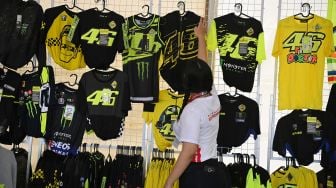 Penjual menata kaos VR46 yang merupakan merek apparel milik legenda MotoGP Valentino Rossi di Pertamina Mandalika International Street Circuit, Lombok Tengah, NTB, Sabtu (19/3/2022).  ANTARA FOTO/Andika Wahyu
