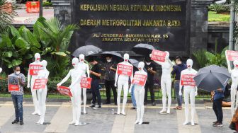 Sejumlah boneka manekin dipajang para aktivis saat melakukan aksi di depan Polda Metro Jaya, Jakarta Selatan, Senin (21/3/2022). [Suara.com/Alfian Winanro]