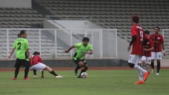 YouTuber Haris Saputra atau Maell Lee menggiring bola saat bermain sepakbola bersama Selebritis FC di Stadion Madya, Kompleks Gelora Bung Karno, Jakarta, Senin (21/3/2022). [Suara.com/Angga Budhiyanto]