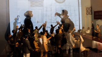 Pengunjung melihat tampilan video mapping mengenai sejarah kongres pemuda di Museum Sumpah Pemuda, Senen, Jakarta Pusat, Selasa (22/3/2022). [Suara.com/Alfian Winanto]