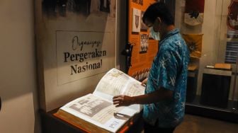 Pengunjung membaca digitalisasi buku sejarah di Museum Sumpah Pemuda, Senen, Jakarta Pusat, Selasa (22/3/2022). [Suara.com/Alfian Winanto]