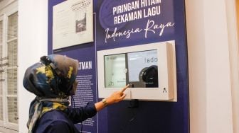 Pengunjung mendengar piringan hitam rekaman lagu Indonesia Raya di Museum Sumpah Pemuda, Senen, Jakarta Pusat, Selasa (22/3/2022). [Suara.com/Alfian Winanto]