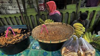 Pedagang pisang goreng melayani pembeli pada lapak dagangannya di Palu, Sulawesi Tengah, Rabu (23/3/2022). ANTARA FOTO/Mohamad Hamzah