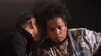 Pemain film Gara-Gara Warisan Satriaddin Maharinga Djongki atau Arie Kriting (kanan) 
berbincang dengan Ernest Prakasa saat acara konferensi pers di Metropole XXI, Jakarta, Kamis (24/3/2022). [Suara.com/Angga Budhiyanto]